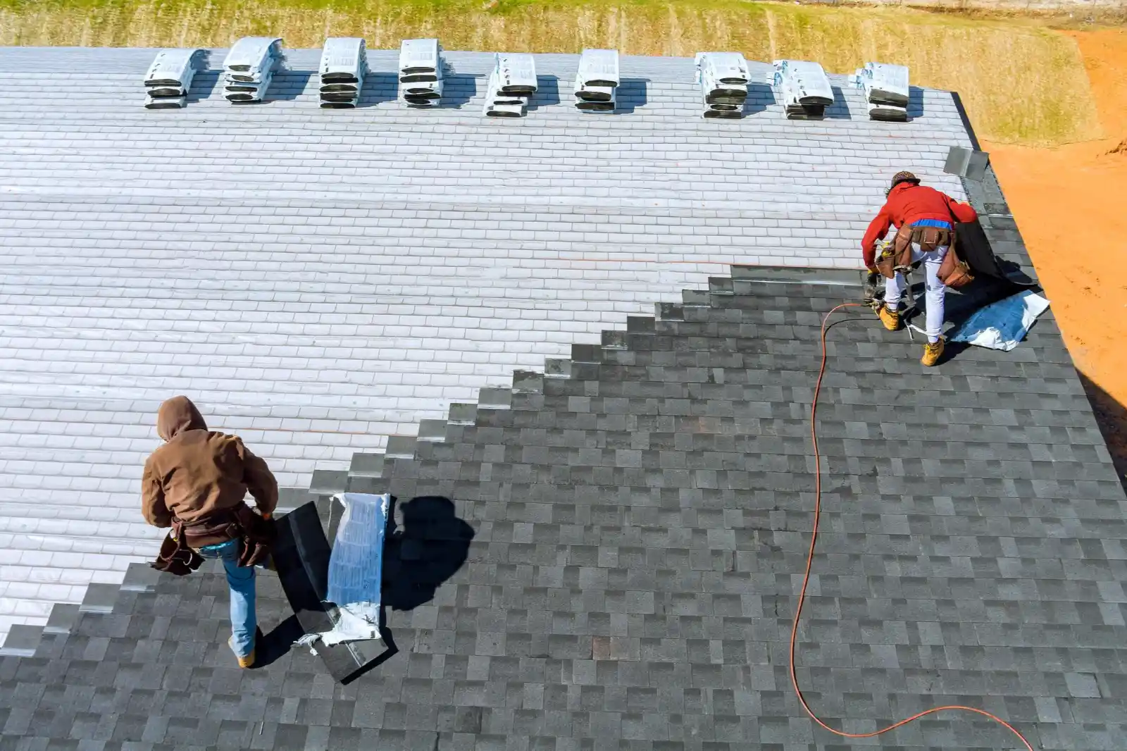 two roofers installing roofing shingles on a house roof in Downers Grove