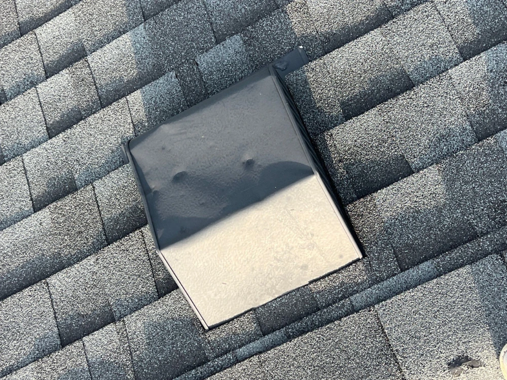 Hail damage to a metal roof vent on a Darien, Illinois home