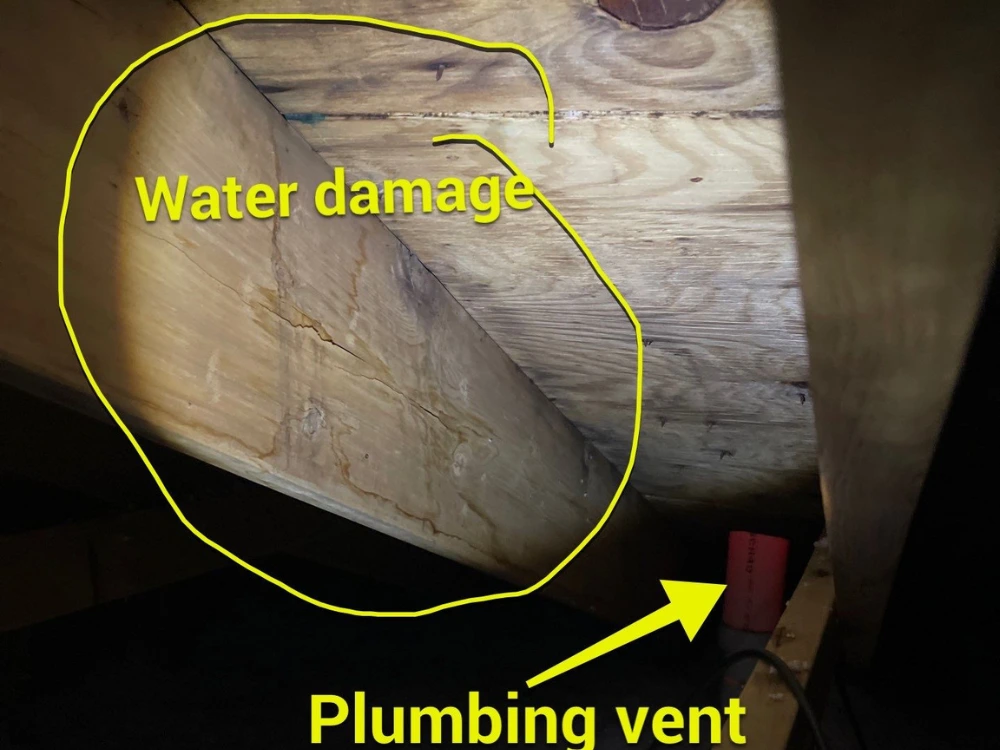 Water damage on a roof deck seen from inside an attic